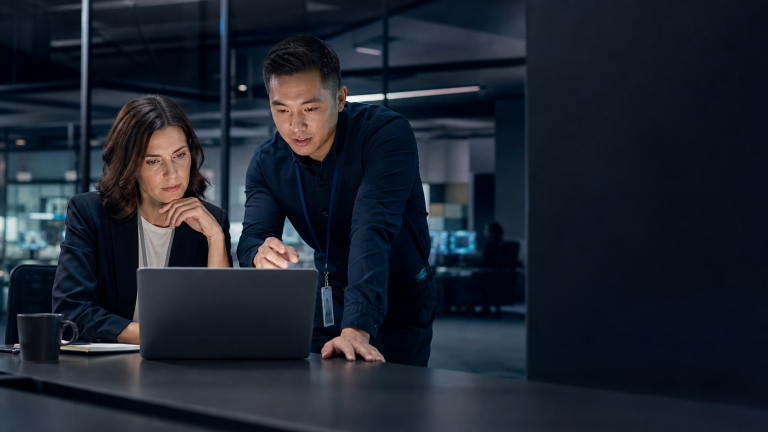 Business professional and IT specialist reviewing a suspicious payment request